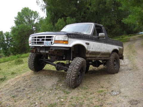 1993 Ford Bronco - This lifted 1993 Ford Bronco is covered in mud, suggesting it has been used for off-roading.