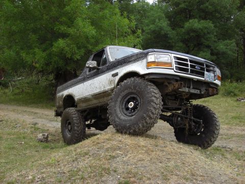 1993 Ford Bronco - This modified 1993 Ford Bronco is shown off-road with its suspension and large tires visible.