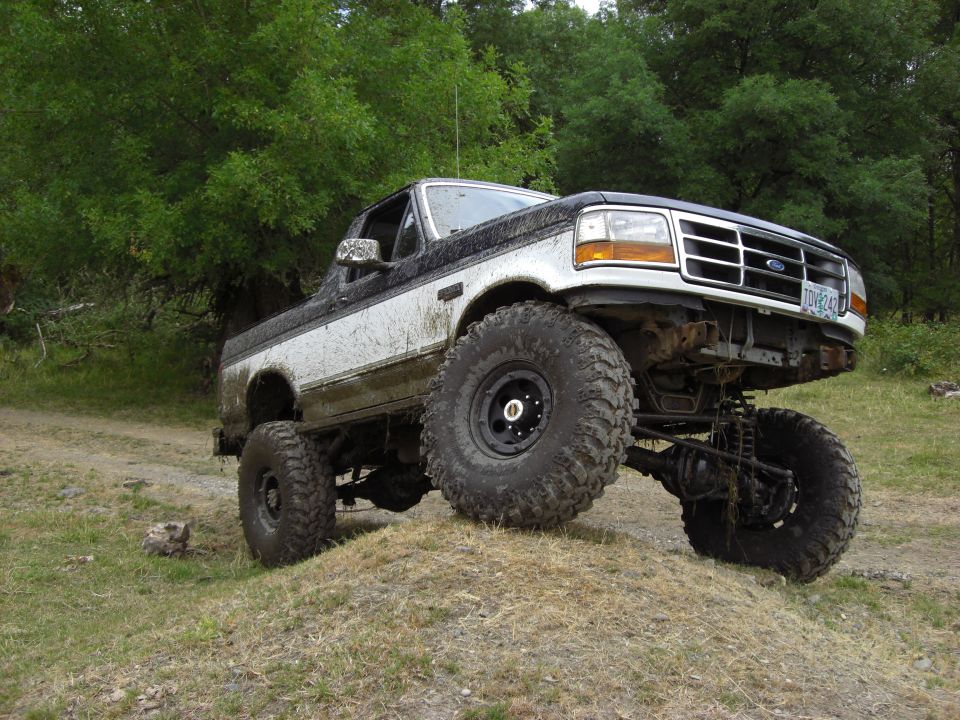 Lifted 1993 Ford Bronco on a dirt mound with large tires
