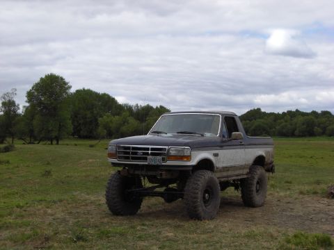 1993 Ford Bronco - This lifted 1993 Ford Bronco is shown in a field under a cloudy sky.