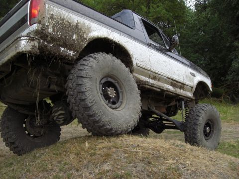 1993 Ford Bronco - This 1993 Ford Bronco is heavily modified for off-road use, covered in mud after driving through rough terrain.