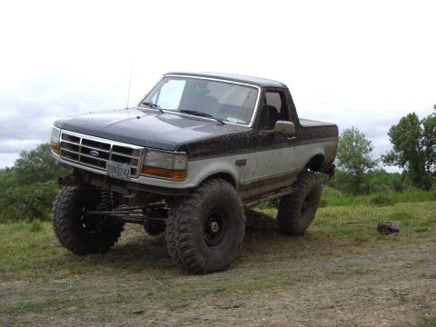 1993 Ford Bronco - This lifted 1993 Ford Bronco features a two-tone paint scheme and is shown in a three-quarter front view.