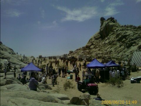 1990 Ford Bronco - crowd of people gather under blue pop-up canopies among large desert boulders and rocky outcrops, date-stamped 2008/06/20.