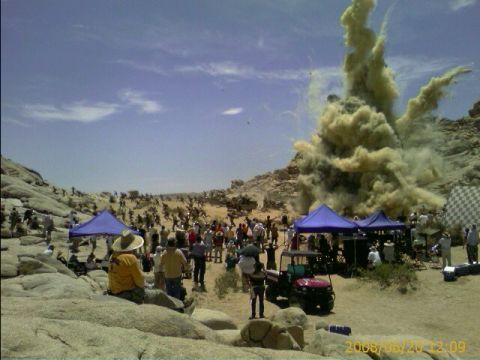 1990 Ford Bronco - large plume of dust erupts from the ground beside a crowd gathered among desert boulders and blue canopies, date-stamped 2008/06/20.