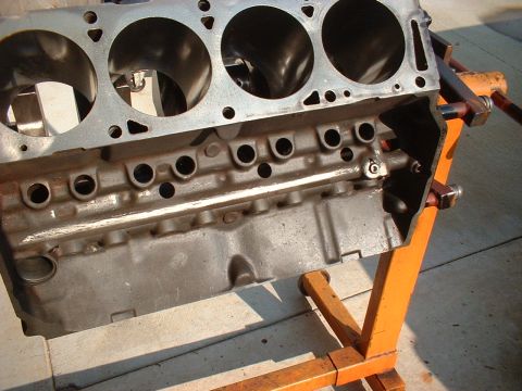 1957 Ford Custom Sedan - A close-up view of a vehicle engine block mounted on an orange stand.