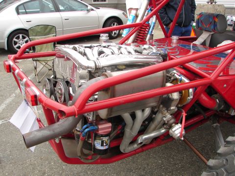 1992 Ford Taurus - A custom red dune buggy is shown with its exposed engine, Yamaha branding and a turbocharger. A silver sedan is visible in the background.