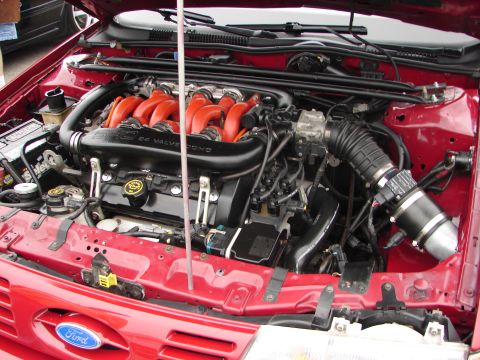 1992 Ford Taurus - The engine bay of a 1992 Ford Taurus shows its 3.0L V6 24-valve engine with prominent red intake runners.