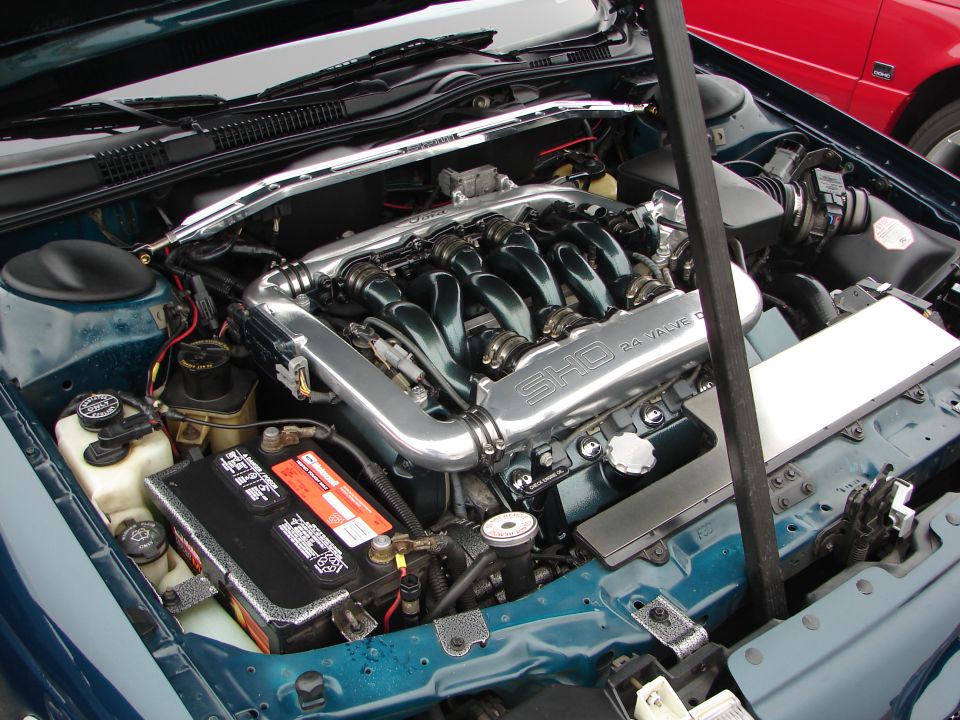 1992 Ford Taurus SHO engine bay with V6 engine, intake manifold, and battery visible