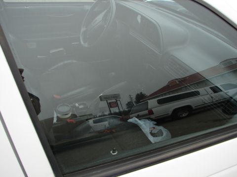 1992 Ford Taurus - The interior of a car is visible through the window, with reflections of trucks outside.