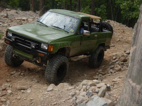 1995 Ford Bronco - This modified pickup truck navigates a challenging off-road course with its lifted suspension and aggressive tires.