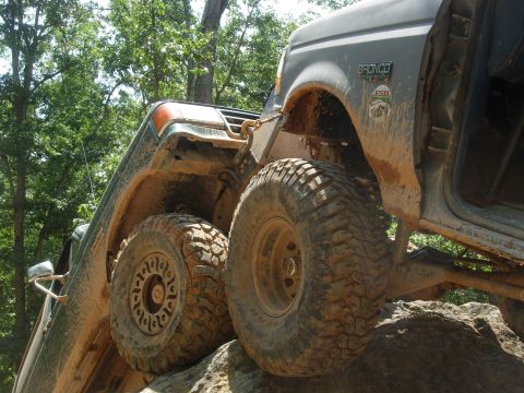 1995 Ford Bronco - Two off-road vehicles are shown navigating a rocky terrain, with one Bronco prominently featured.