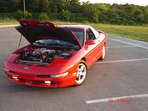 1993 Ford Probe - A red 1993 Ford Probe is parked with its hood open, revealing the engine compartment.