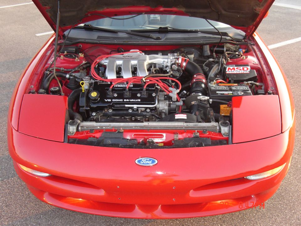 Red 1993 Ford Probe engine bay with hood open. Shows V6 DOHC 24-valve Mazda engine
