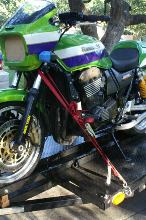 1981 Kawasaki Bayou - A green and purple Kawasaki motorcycle is secured with straps to a trailer ramp, with 'Race Tech' visible on the front fork.