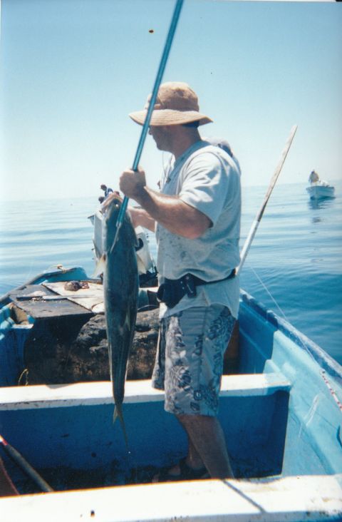 1994 Ford Bronco - A man proudly displays his catch while fishing from a boat on a clear day.