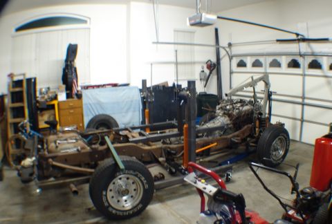 1996 Ford Bronco - This vehicle is undergoing restoration or repair, with the frame and engine exposed in a garage setting.