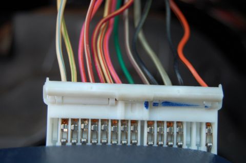 1985 Mercury Grand Marquis - A white electrical connector with numerous wires is shown, with a blue mark on the housing.