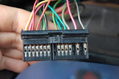 1985 Mercury Grand Marquis - A close-up view of a vehicle's wiring harness connector, showing various colored wires and metal terminals.