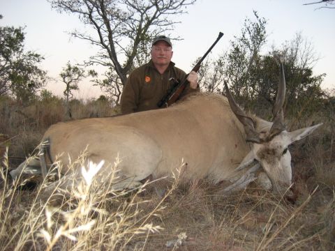 1991 Ford Bronco - A hunter poses with his kill, a large antelope, in a dry, outdoor environment.