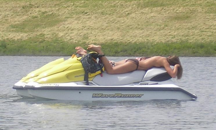 Person sunbathing on a WaveRunner jet ski in the water