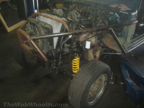 1987 Suzuki Samurai - Front view of a 1987 Suzuki Samurai undergoing modifications with a custom roll cage and new radiator.
