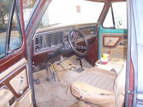 1979 Ford Bronco - The interior of a 1979 Ford Bronco shows a worn dashboard and ripped driver's seat.
