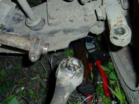 2000 Ford E350 - A damaged vehicle suspension part is shown with cutting tools in the background.