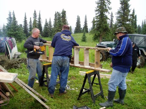 2000 Ford E350 - People work on a wooden structure outdoors, with a Jeep Wrangler visible in the background.