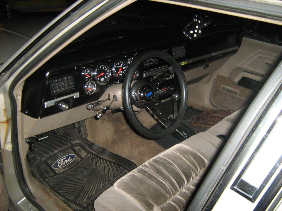 Interior dashboard and steering wheel of an older Ford vehicle