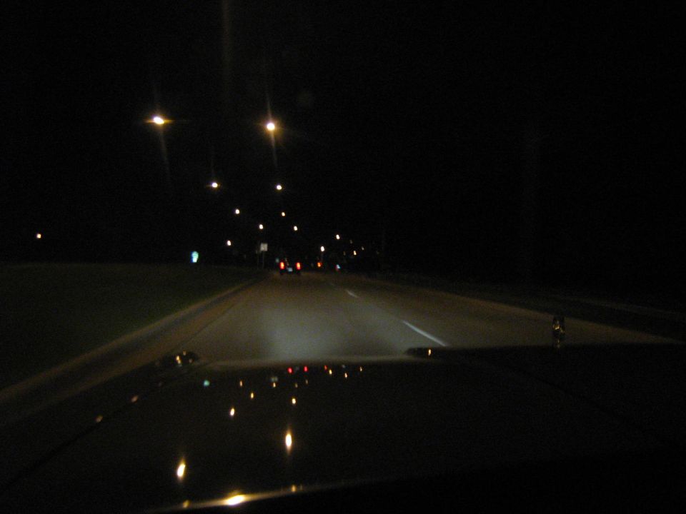 Nighttime view of a highway through a vehicle windshield