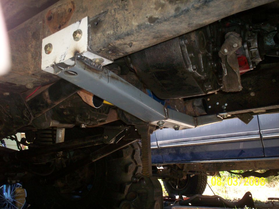 New bare-steel crossmember bolted to 4x4 frame rail under transmission and transfer case