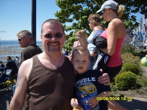 1989 Ford Bronco - A man and a young boy pose for a photo outdoors. The man is wearing a brown tank top and sunglasses, and the boy is wearing a black t-shirt…