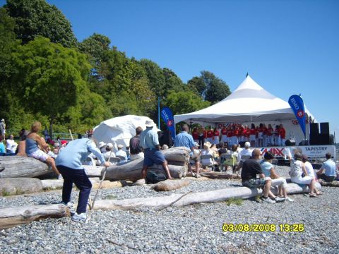 1989 Ford Bronco - A choir performs on a stage under a large white tent in front of a body of water and trees. Several people are seated in the audience on th…