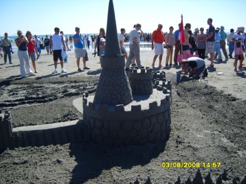 1989 Ford Bronco - A large sandcastle is the main focus of this beach scene, with a crowd of people gathered in the background. The sandcastle is elaborate, f…