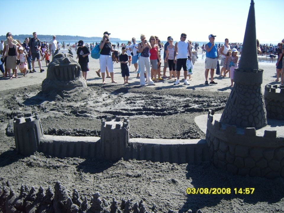 Elaborate sandcastle on a beach with spectators