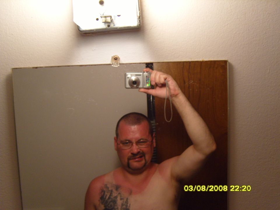 Man taking a selfie in a mirror with a digital camera.