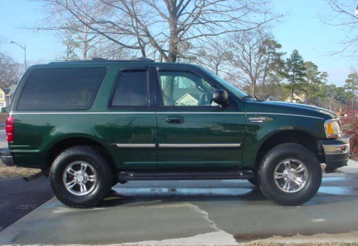 Side view of a dark green two-door Ford SUV with Expedition badge, chrome wheels and running boards