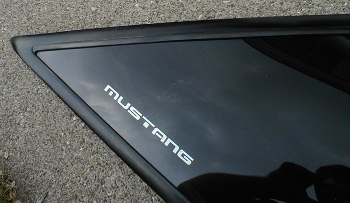 Black quarter-window trim panel with chrome MUSTANG lettering