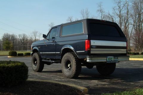 1992 Ford Bronco - This 1992 Ford Bronco is shown from the rear 3/4 angle, its dark blue paint and off-road tires.