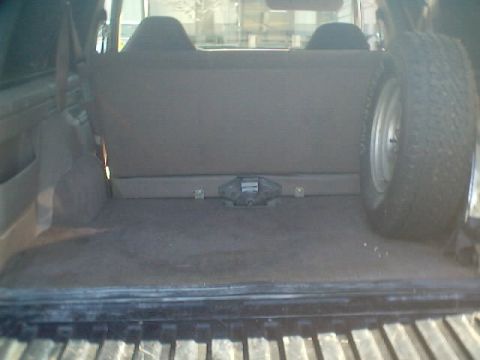 1992 Ford Bronco - Interior view of a 1992 Ford Bronco, showing the cargo space and a spare tire.