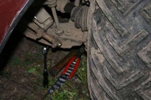 1990 Chevrolet Suburban - Close-up of vehicle undercarriage with tools scattered on the ground.