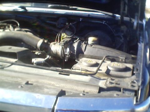1992 Ford Bronco - The engine bay of a vehicle is shown, the air intake system and other engine components.