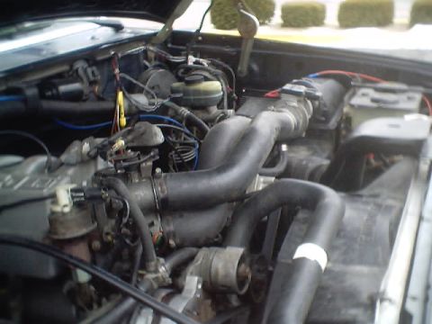 1992 Ford Bronco - The engine bay of a 1992 Ford Bronco shows various hoses, wires, and engine components.