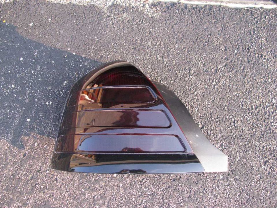 Dark red tinted tail light assembly on gravel