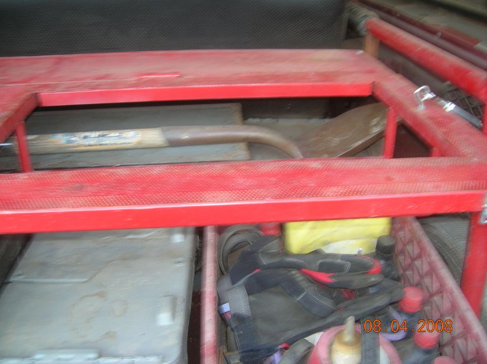 Storage area in a vehicle with tools and a date stamp.