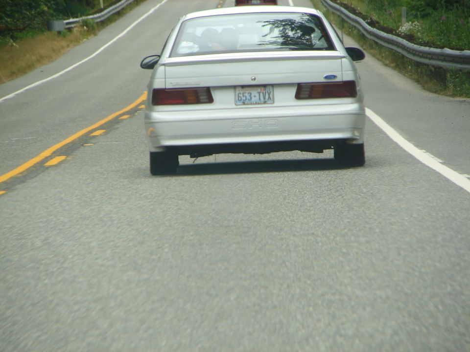Rear view of a white 1992 Ford Taurus SHO with license plate 653-TVX