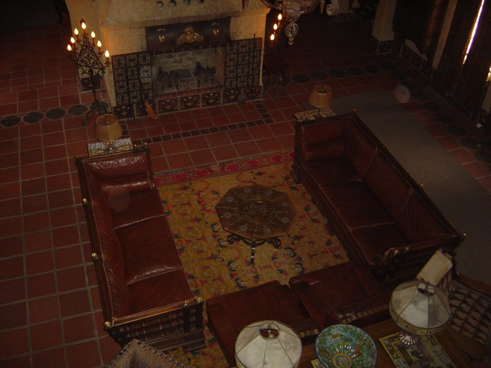 Interior scene with fireplace, leather sofas, rug, and lamps.