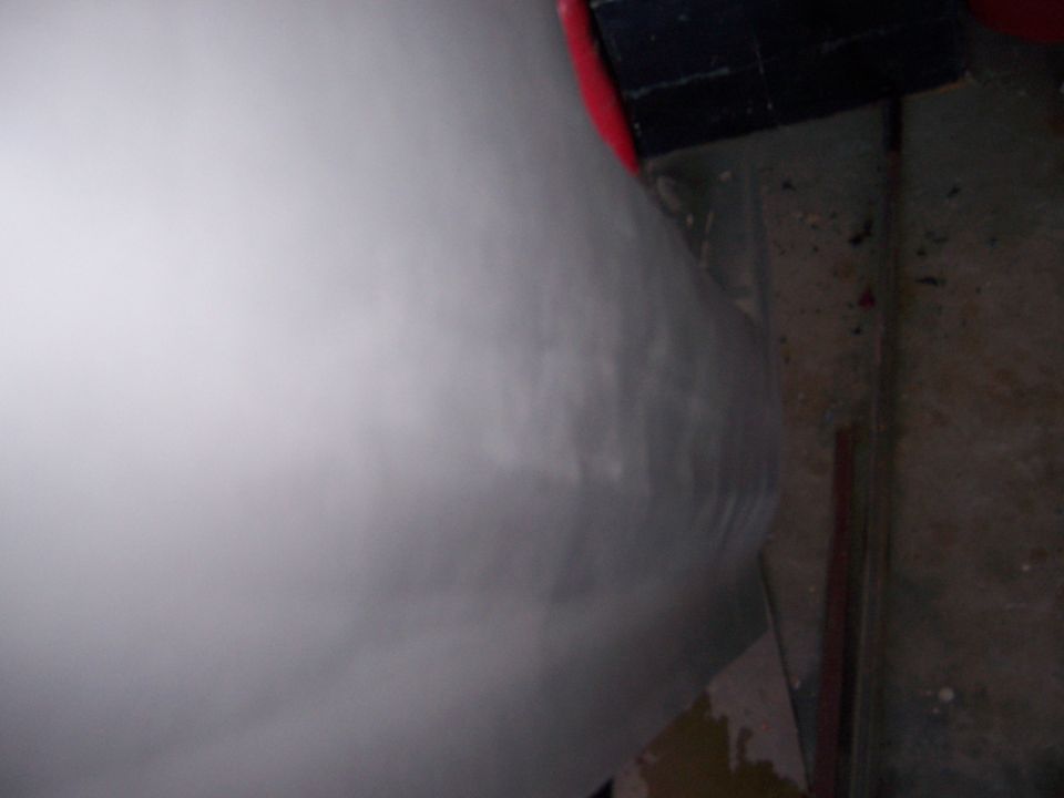 Close-up of a white, unpainted vehicle body panel with some scuff marks