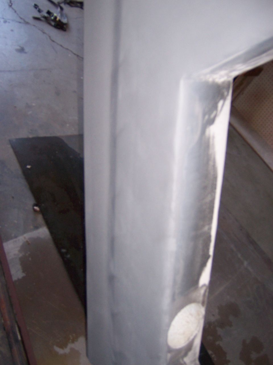 Photo of a primed vehicle body panel standing in a shop