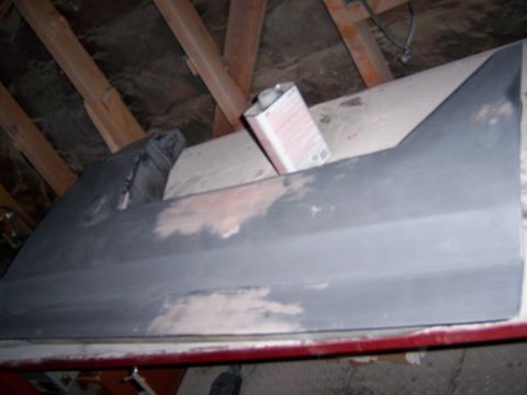 1991 Ford Bronco - A car door panel is prepped for paint in an attic space.